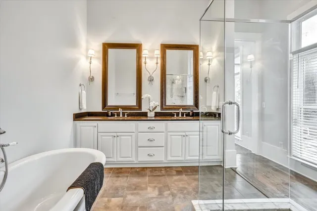 a spacious bathroom with a tub sink and mirror