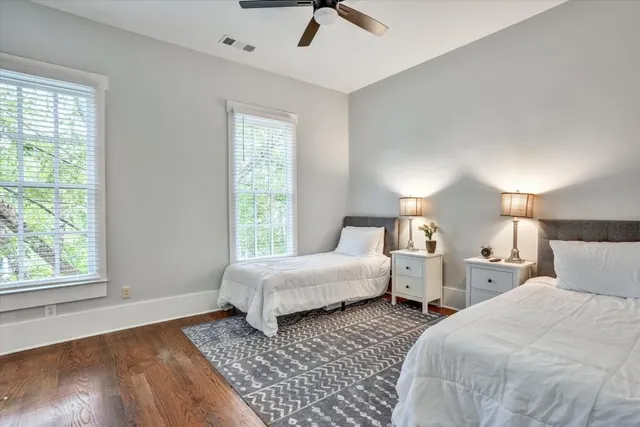 a bedroom with two beds and a large window