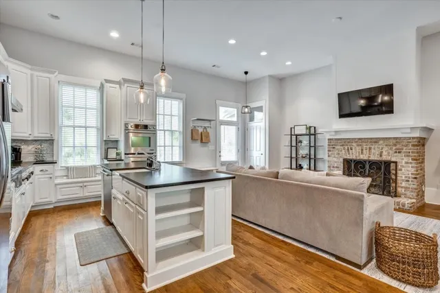 a large kitchen with granite countertop a stove and a sink dishwasher with wooden floor