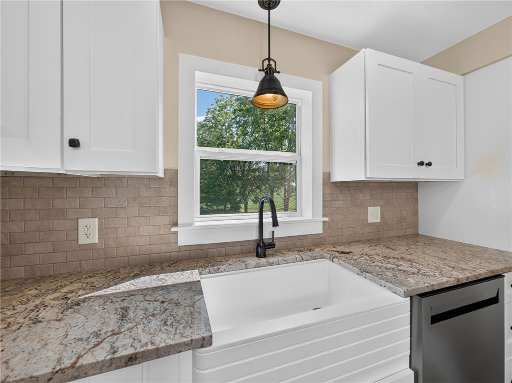 291 East Dannersville Road Bath, PA 18014 - Photo 33 of 46 A well-lit kitchen features granite counters, white cabinetry, and a modern farmhouse sink beneath a bright window.
