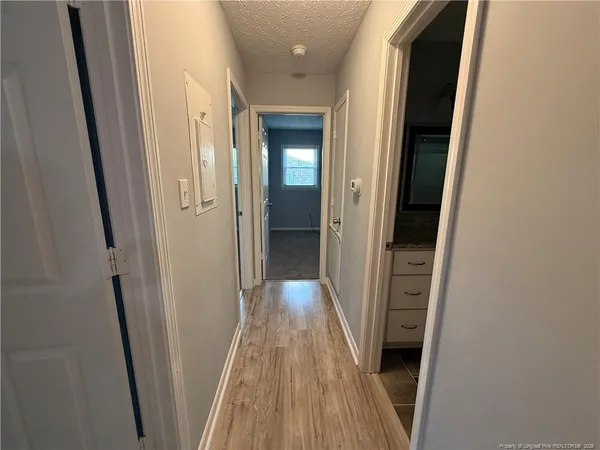 a view of a hallway with wooden floor and entryway