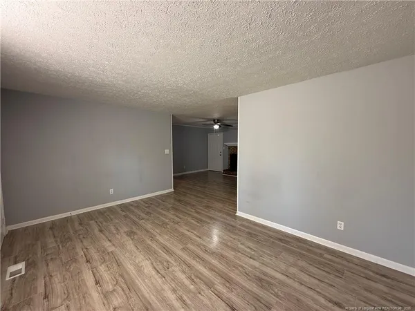 a view of an empty room with wooden floor