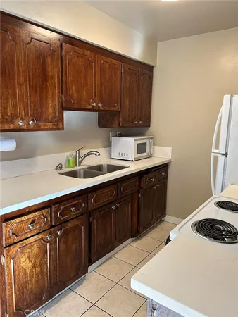 a kitchen with a sink a stove and cabinets