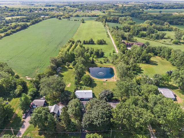 an aerial view of a residential houses with yard