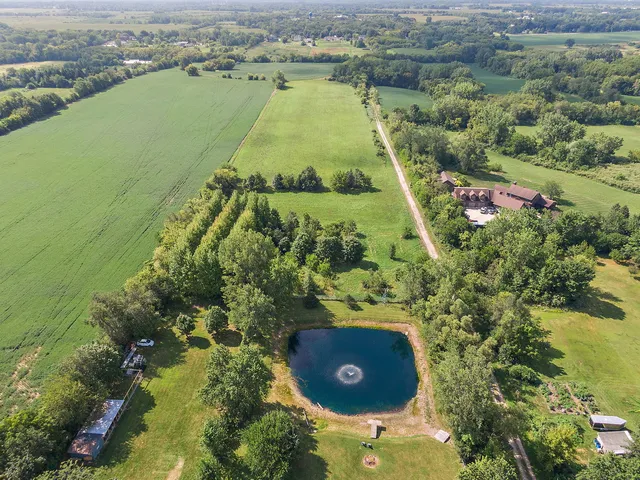 an aerial view of a house with a yard and lake view