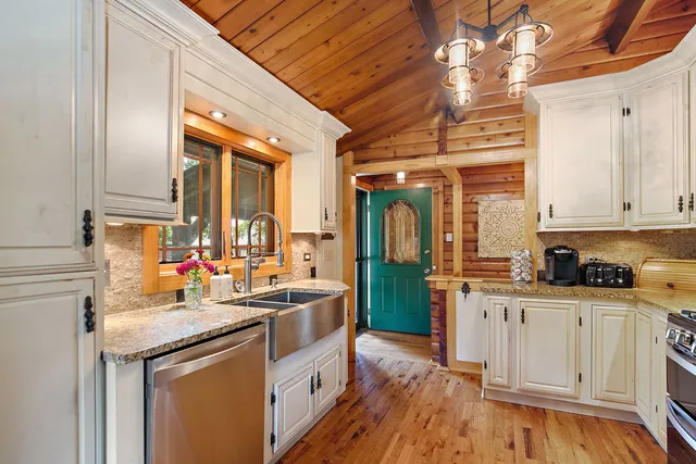 a kitchen with granite countertop a sink appliances and cabinets