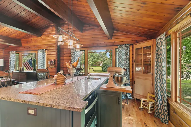 a dining hall with stainless steel appliances granite countertop a sink a wooden floor
