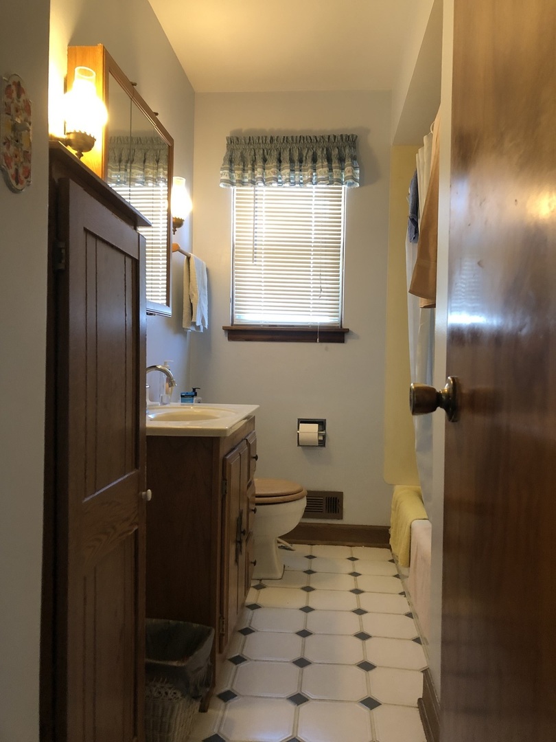 1208 Waverly Place Joliet, IL 60435 - Photo 8 of 18 a bathroom with a sink a toilet and a mirror