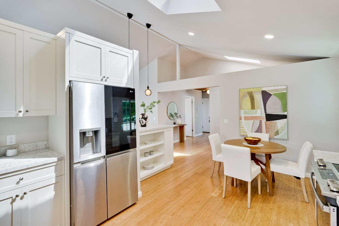 1755 Ravizza Avenue Santa Clara, CA 95051 - Photo 13 of 36 a kitchen with stainless steel appliances a refrigerator a stove a dining table and chairs with wooden floor