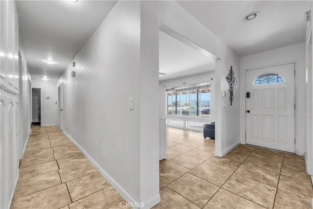 a view of a hallway to a room with wooden floor and a bathroom