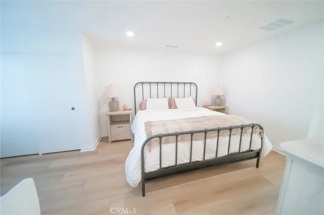 a bedroom with a bed with a white comforter