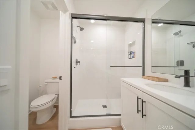 a bathroom with a granite countertop sink toilet and shower