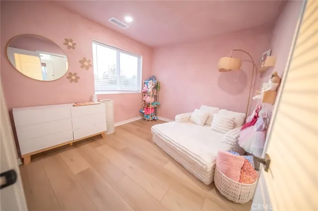 a bedroom with a bed mirror and a window