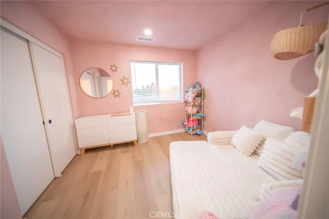 a bedroom with a bed mirror and a window