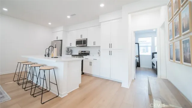a kitchen with white cabinets and sink