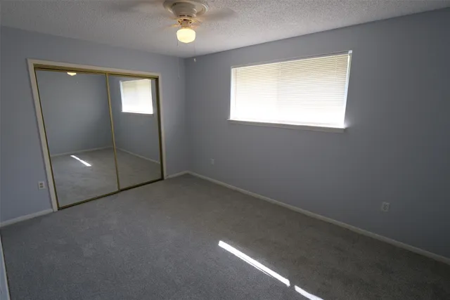 an empty room with fan and entrance
