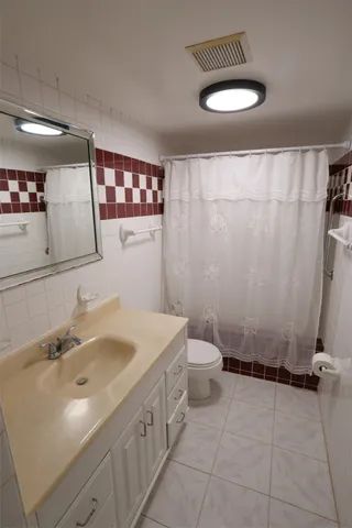 an empty room with a chandelier fan and windows