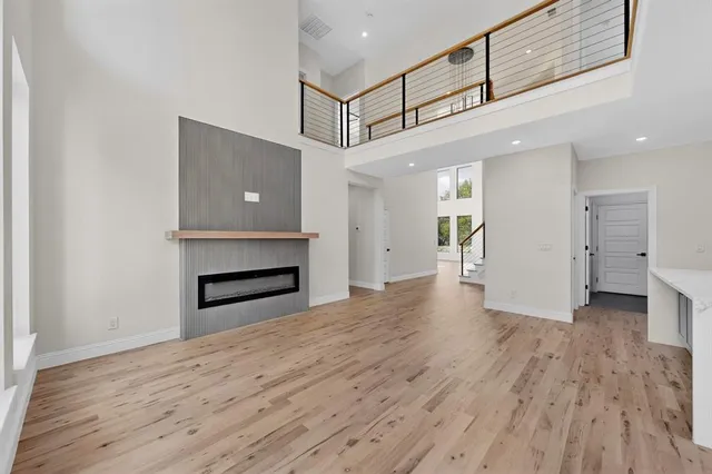a view of a hallway with wooden floor and a kitchen