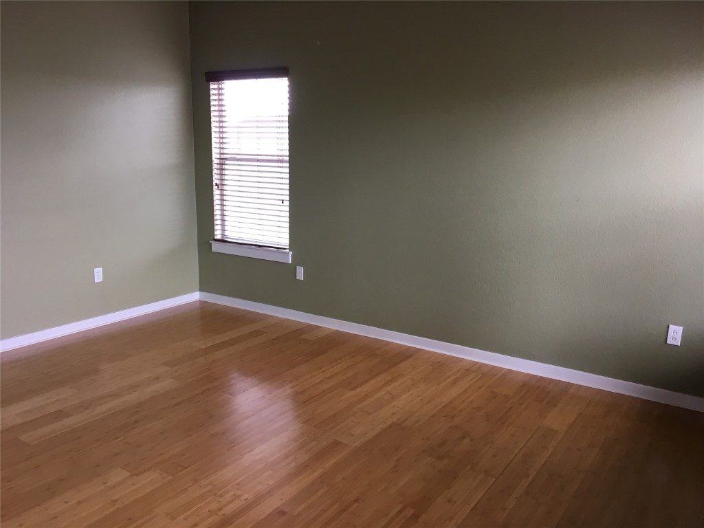 1924 Littlefield Street Austin, TX 78723 - Photo 18 of 19 an empty room with wooden floor and windows