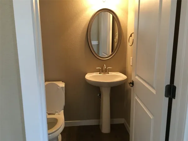 a bathroom with a sink toilet and a mirror