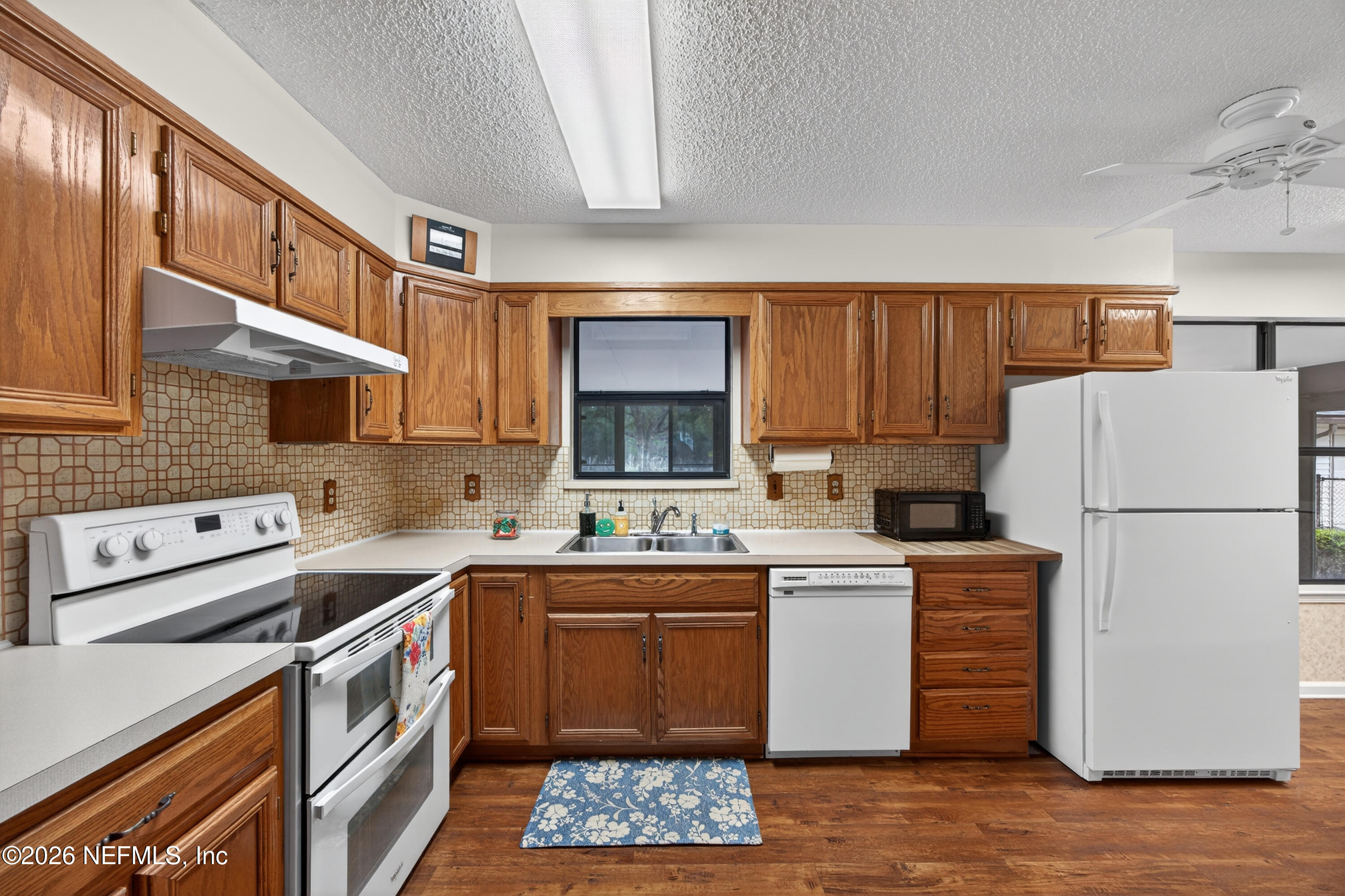 4537 Junction Drive Middleburg, FL 32068 - Photo 19 of 62 a kitchen with a sink a stove a refrigerator and cabinets