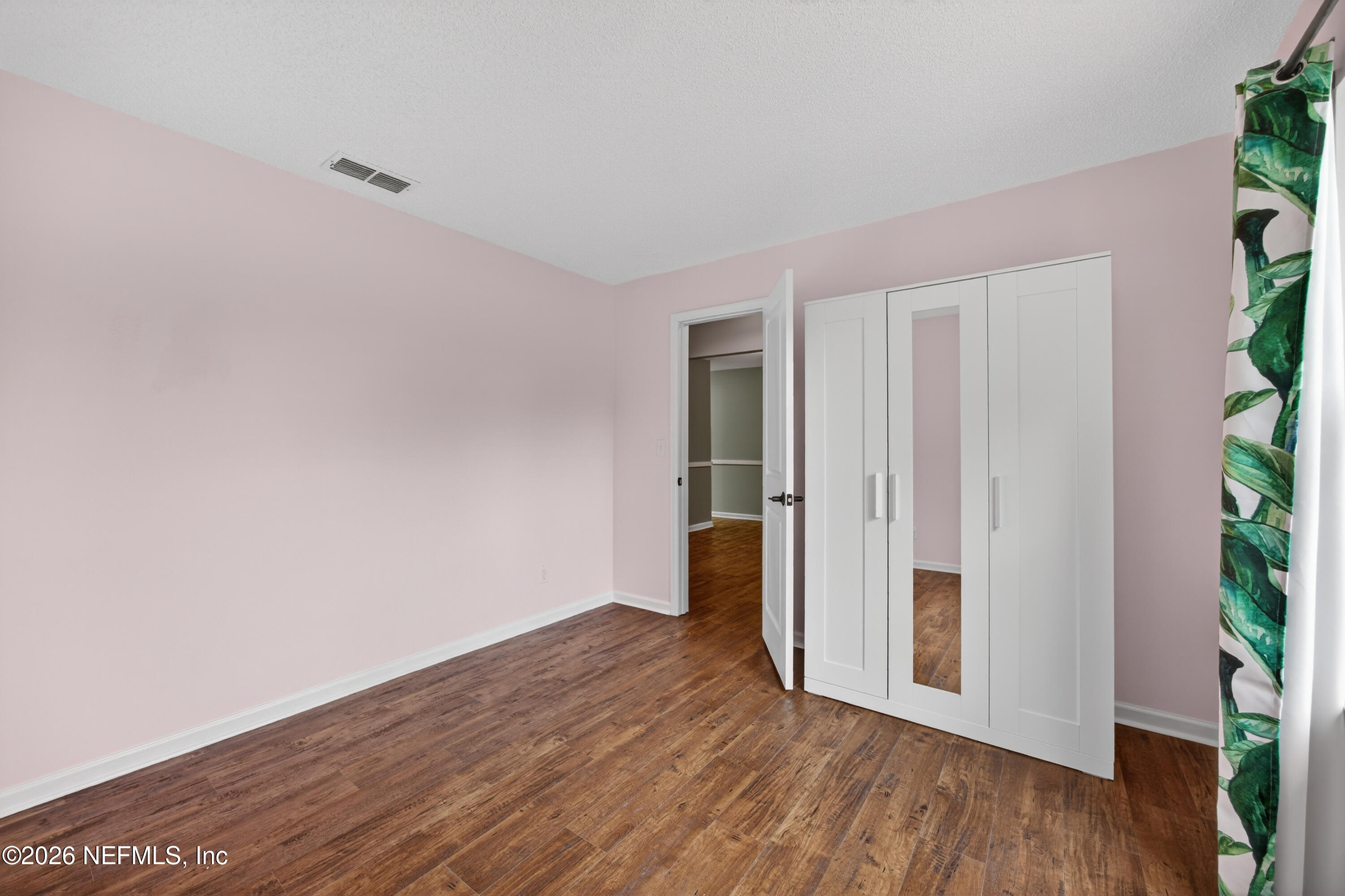 4537 Junction Drive Middleburg, FL 32068 - Photo 10 of 62 a view of an empty room with wooden floor and a potted plant