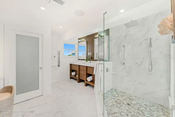 a bathroom with a double vanity sink mirror and shower