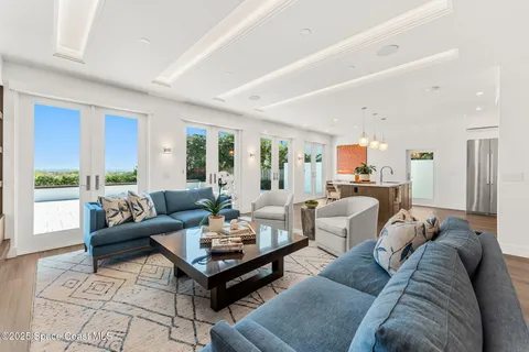 a living room with furniture potted plant and a large window