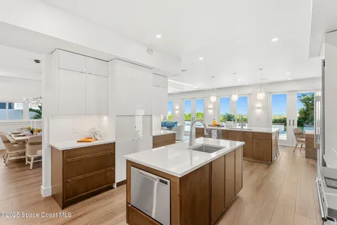 a kitchen with a refrigerator a stove a sink dishwasher and white cabinets with wooden floor