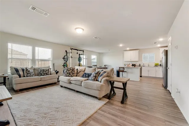 a living room with furniture and a wooden floor
