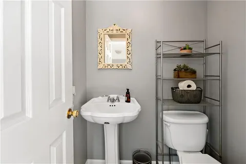 a bathroom with a toilet sink and mirror