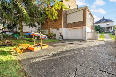 a view of a house with backyard and a tree