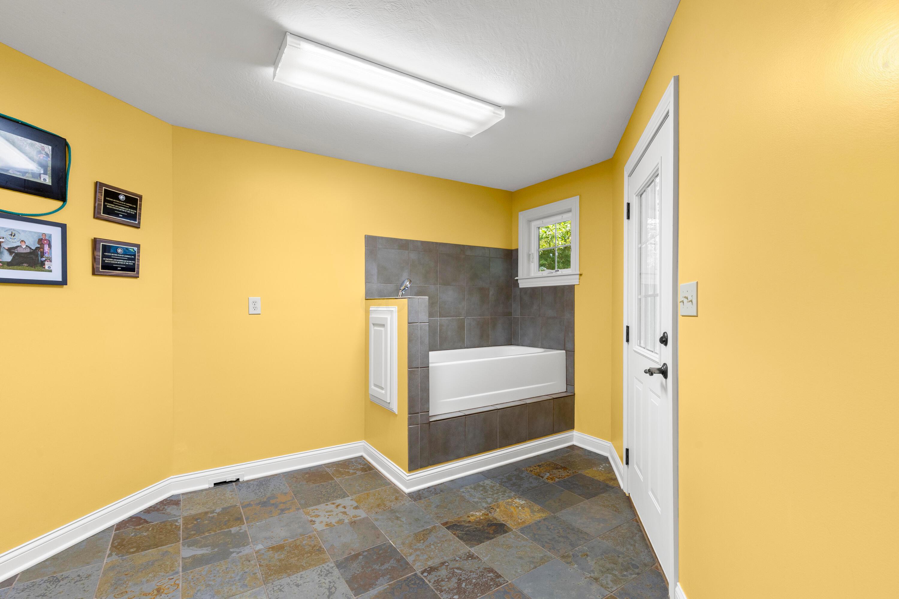 5701 Lancaster-Circleville Road Southwest Lancaster, OH 43130 - Photo 43 of 144 • Slate tile flooring • Gold painted walls • Elevated tub with ceramic tile surround • Ceiling light • Elderwood cabinets • Ceramic tile countertops