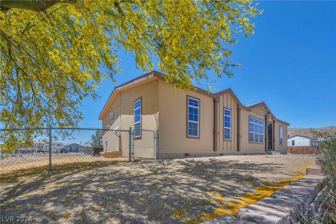 225 California Street Searchlight, NV 89046 - Photo 3 of 64 A well-maintained facade with vertical siding accents and an inviting entry awaits.