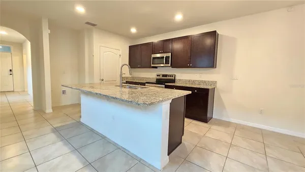 a kitchen with a sink a microwave and cabinets