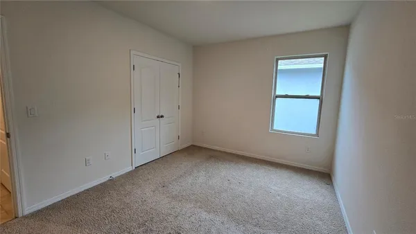 an empty room with a window and closet