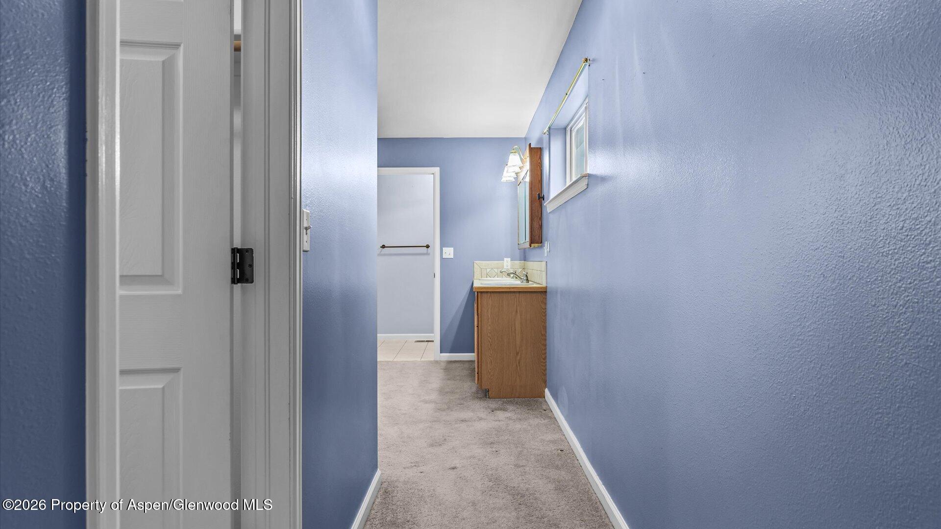 1459 Anvil View Avenue Rifle, CO 81650 - Photo 14 of 29 a view of a hallway with wooden floor and a bathroom