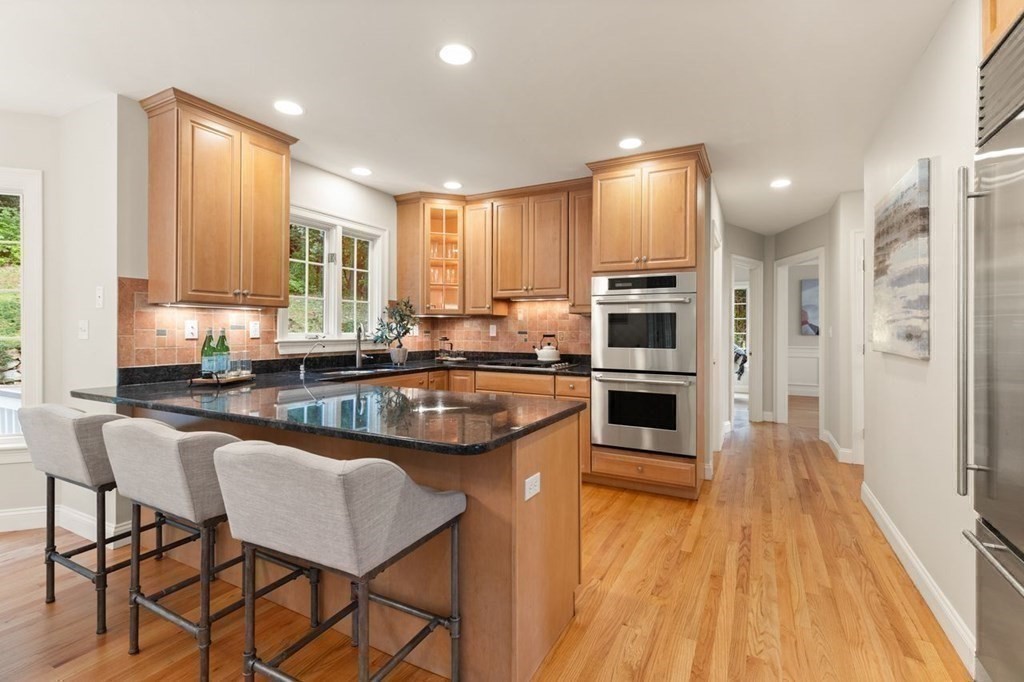 155 Old Spring Street Lexington, MA 02421 - Photo 8 of 28 a kitchen with stainless steel appliances granite countertop a stove a sink a microwave a refrigerator white cabinets and wooden floor