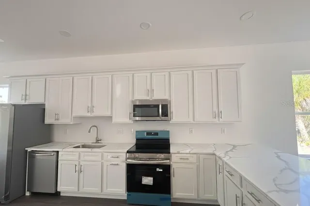 a kitchen with white cabinets and stainless steel appliances