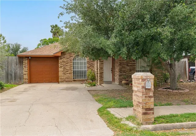 a front view of a house with a yard garage and fountain