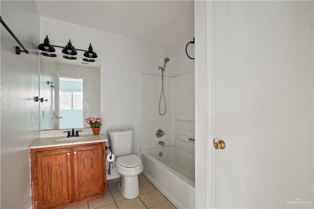 6402 South Mars Lane Pharr, TX 78577 - Photo 9 of 17 a bathroom with a granite countertop sink a toilet and shower