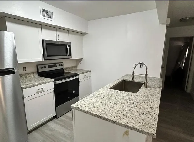 a kitchen with a sink and a stove top oven