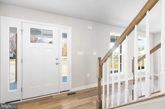 a view of an entryway with wooden floor and door