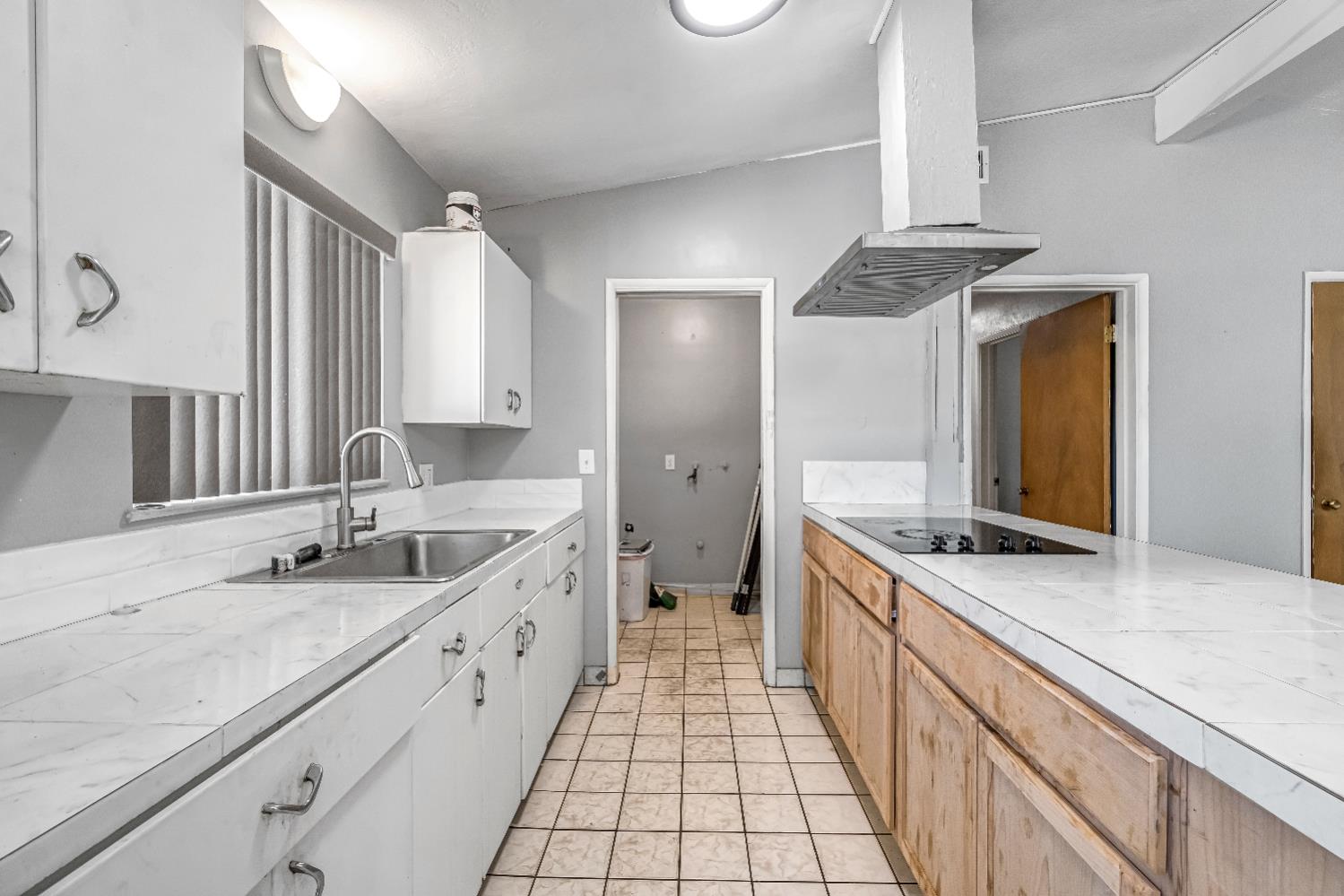 835 I Street Parlier, CA 93648 - Photo 12 of 27 a large white kitchen with a sink and a large mirror