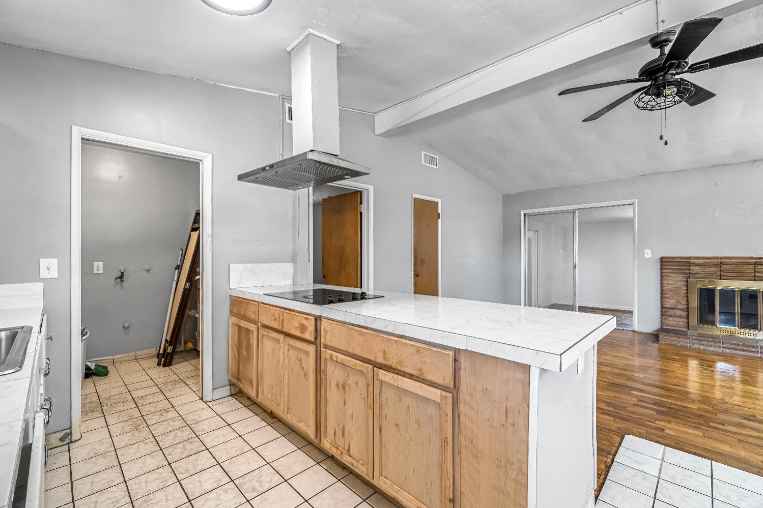 835 I Street Parlier, CA 93648 - Photo 13 of 27 a large white kitchen with a sink and dishwasher a stove top oven with wooden floor