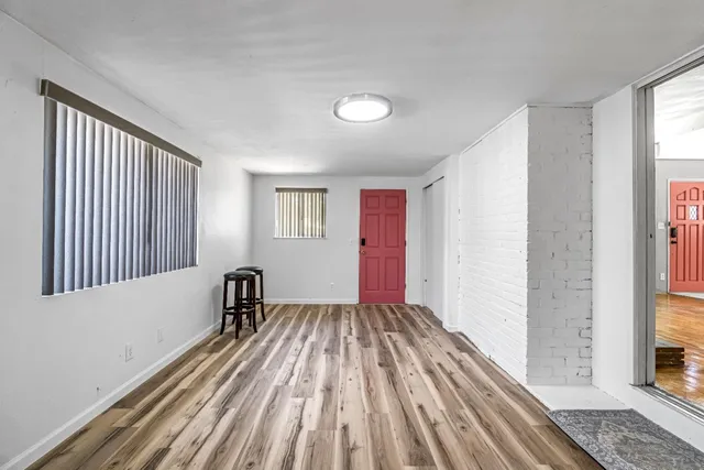 a view of a room with wooden floor and a window