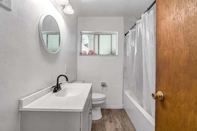 a bathroom with a toilet a sink and mirror