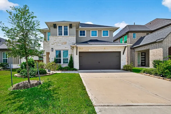 a front view of a house with a yard and garage