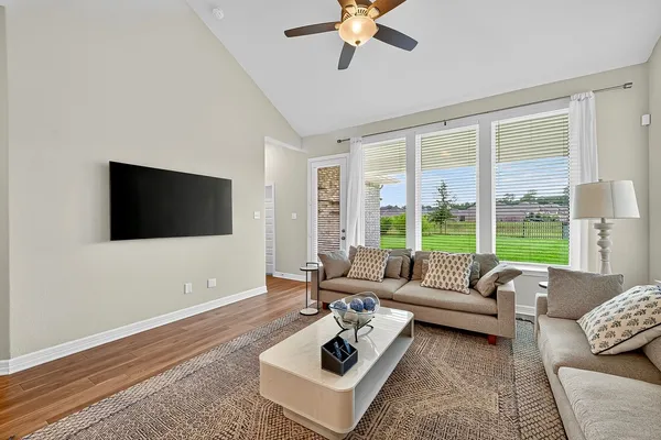 a living room with furniture and a large window with balcony view