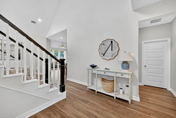 a view of a hallway with wooden floor and stairs